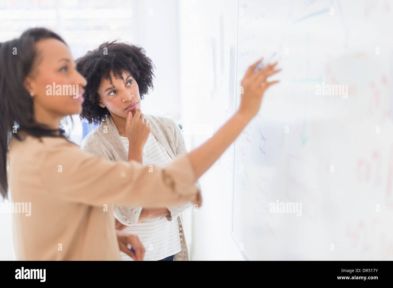 African American businesswomen at whiteboard in office Stock Photo