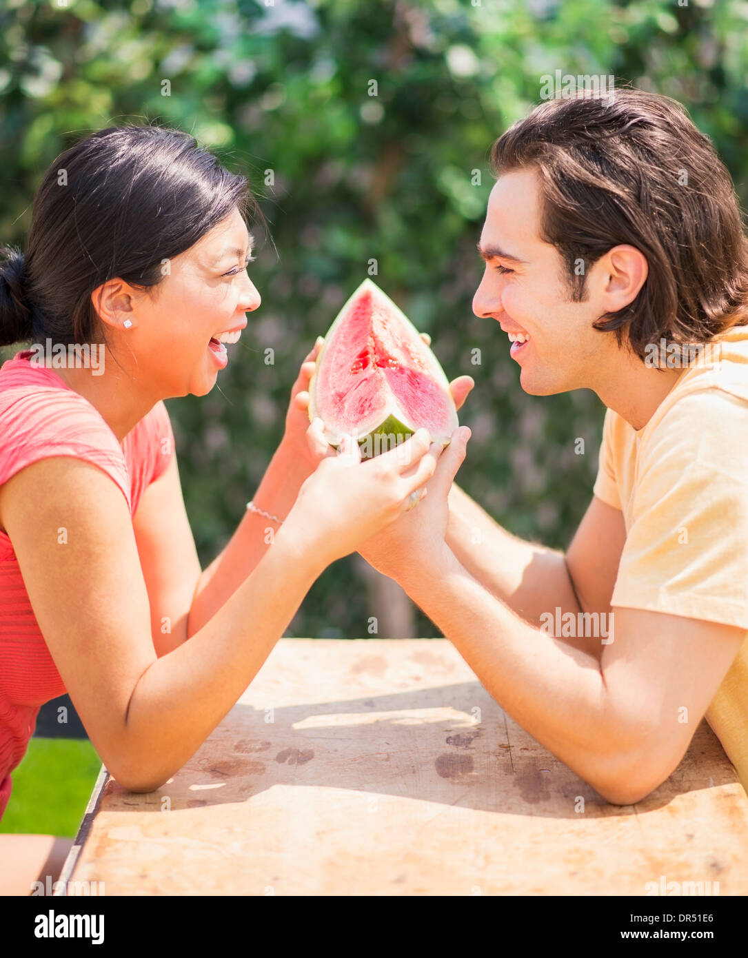 Couple sharing watermelon slice outdoors Stock Photo