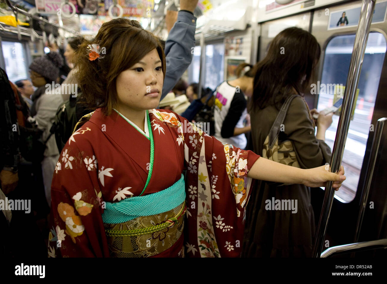 Dec 15, 2008 - Tokyo, Japan - In a traditional kimono, a young woman rides the train. Tokyo's subway system is well developed and organised. With trains arriving every two minutes, some stations can transport more than one million passengers a day. Stock Photo