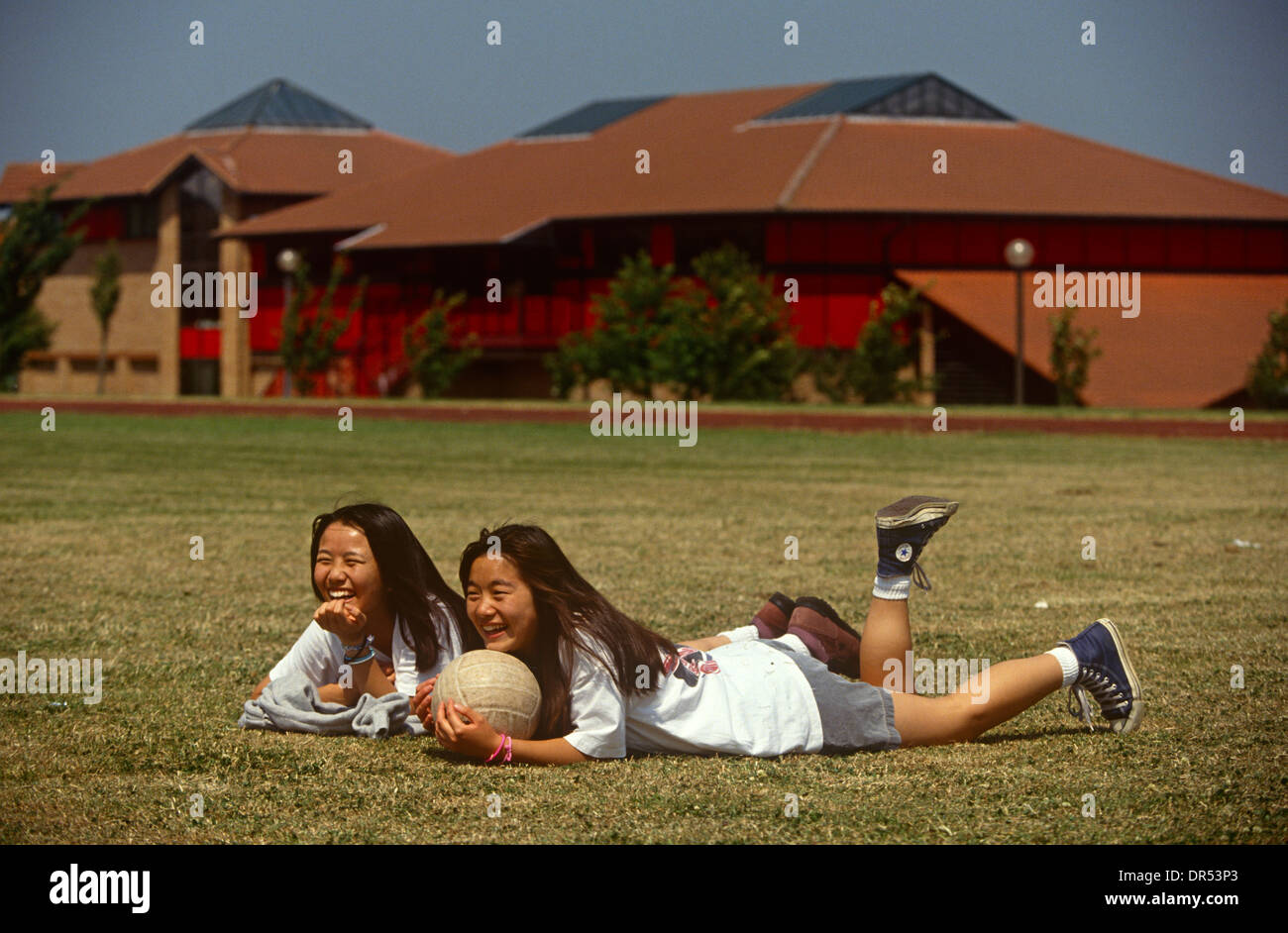 Teenage girl students sit on the sports field at the Gyosei International Japanese School, a boarding school for ex-pats. Stock Photo