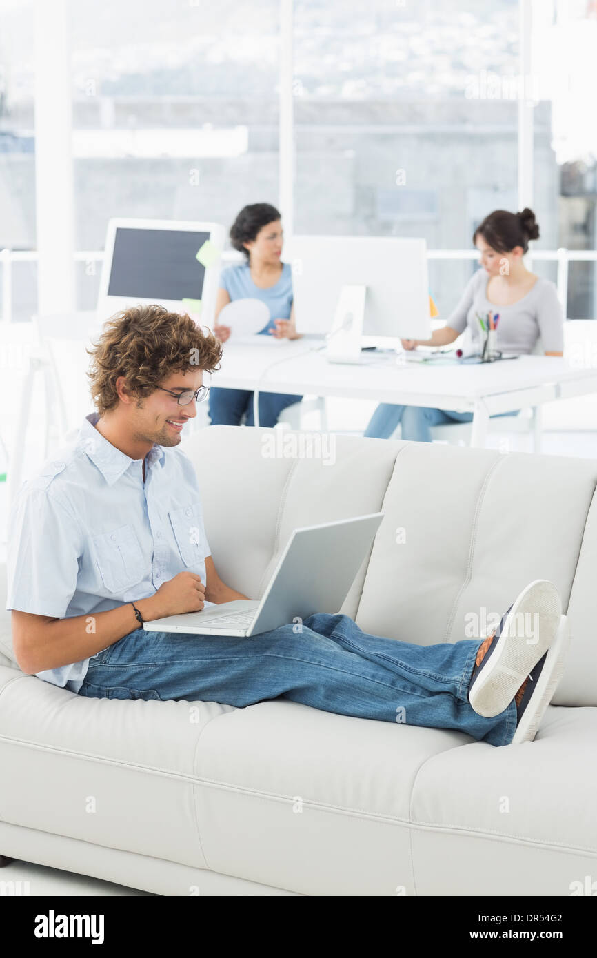 Man using laptop with colleagues at creative office Stock Photo