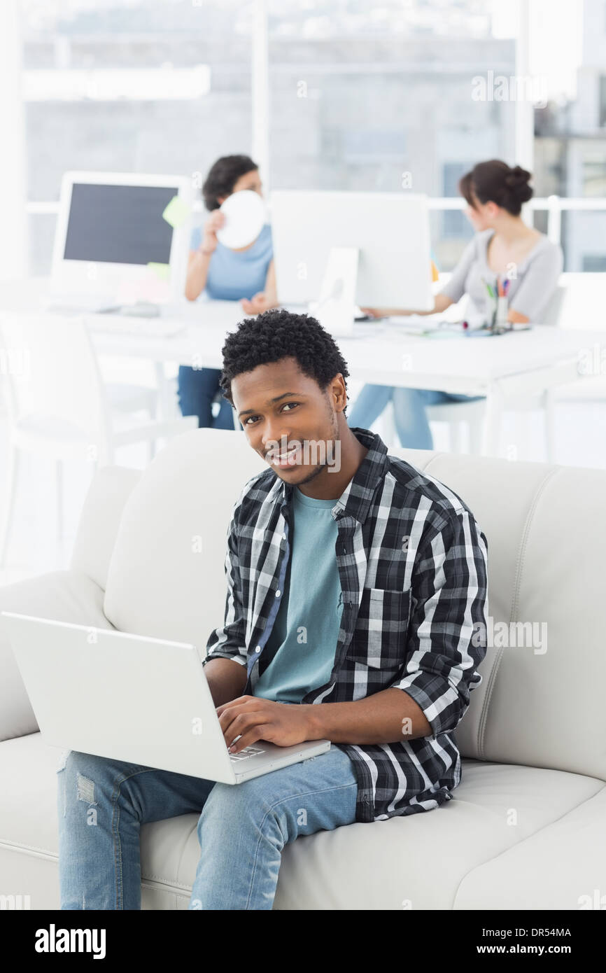 Man using laptop with colleagues at creative office Stock Photo