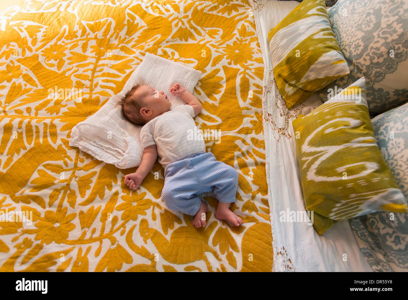 Caucasian baby laying on bed Stock Photo