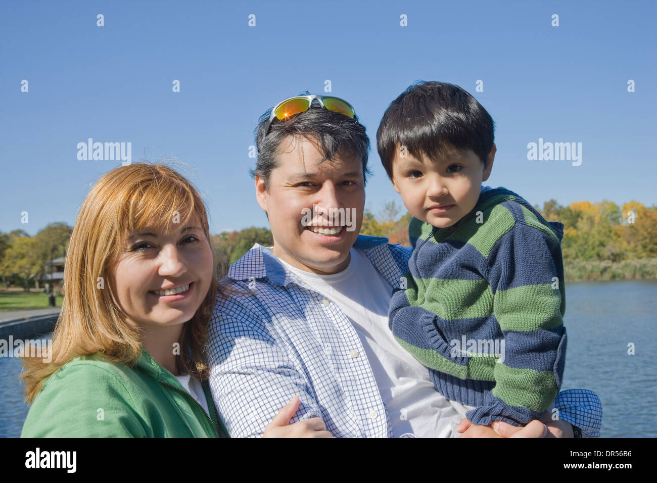 Hispanic family smiling at lakeside Stock Photo - Alamy