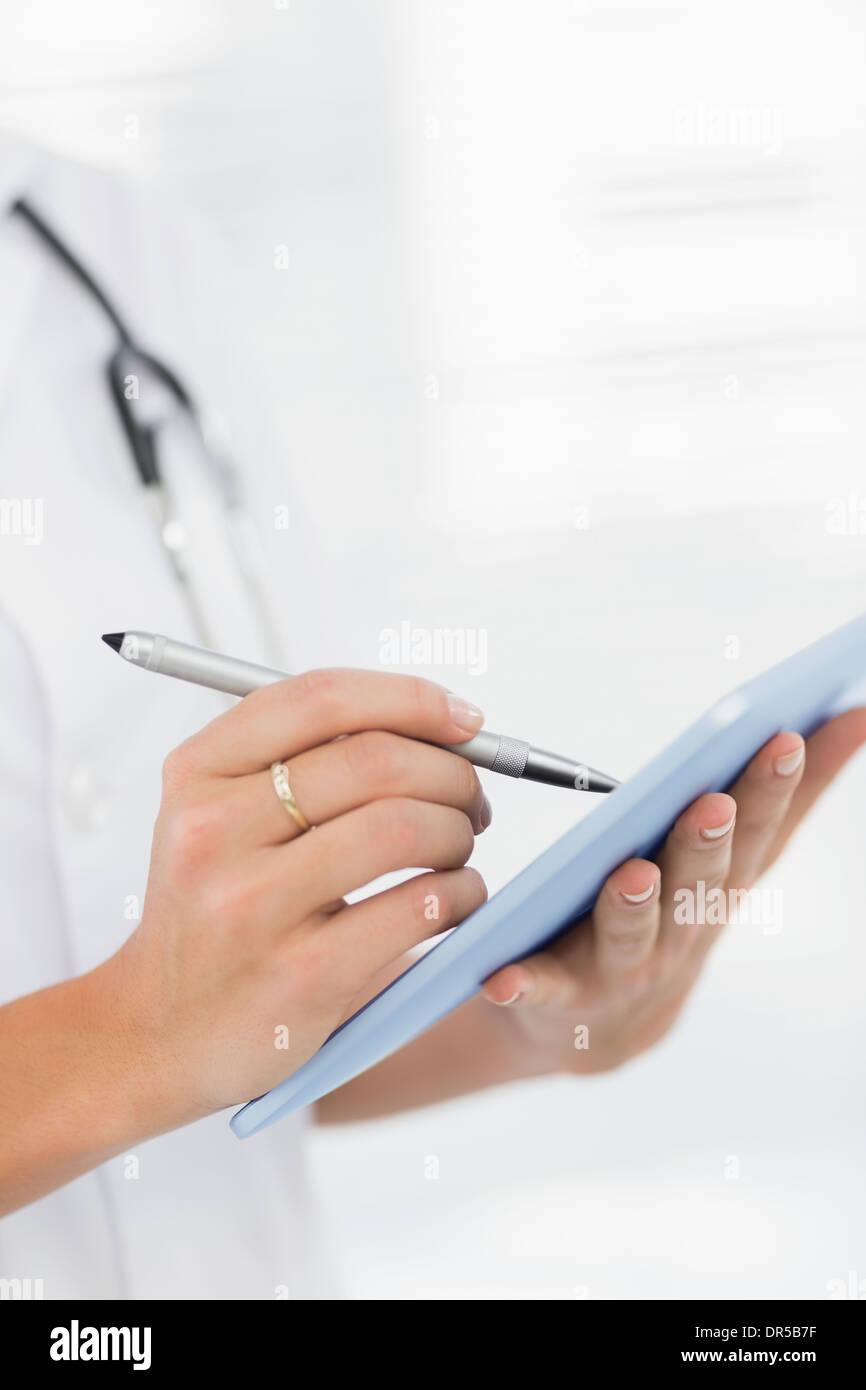 Mid section of a female doctor using digital tablet Stock Photo