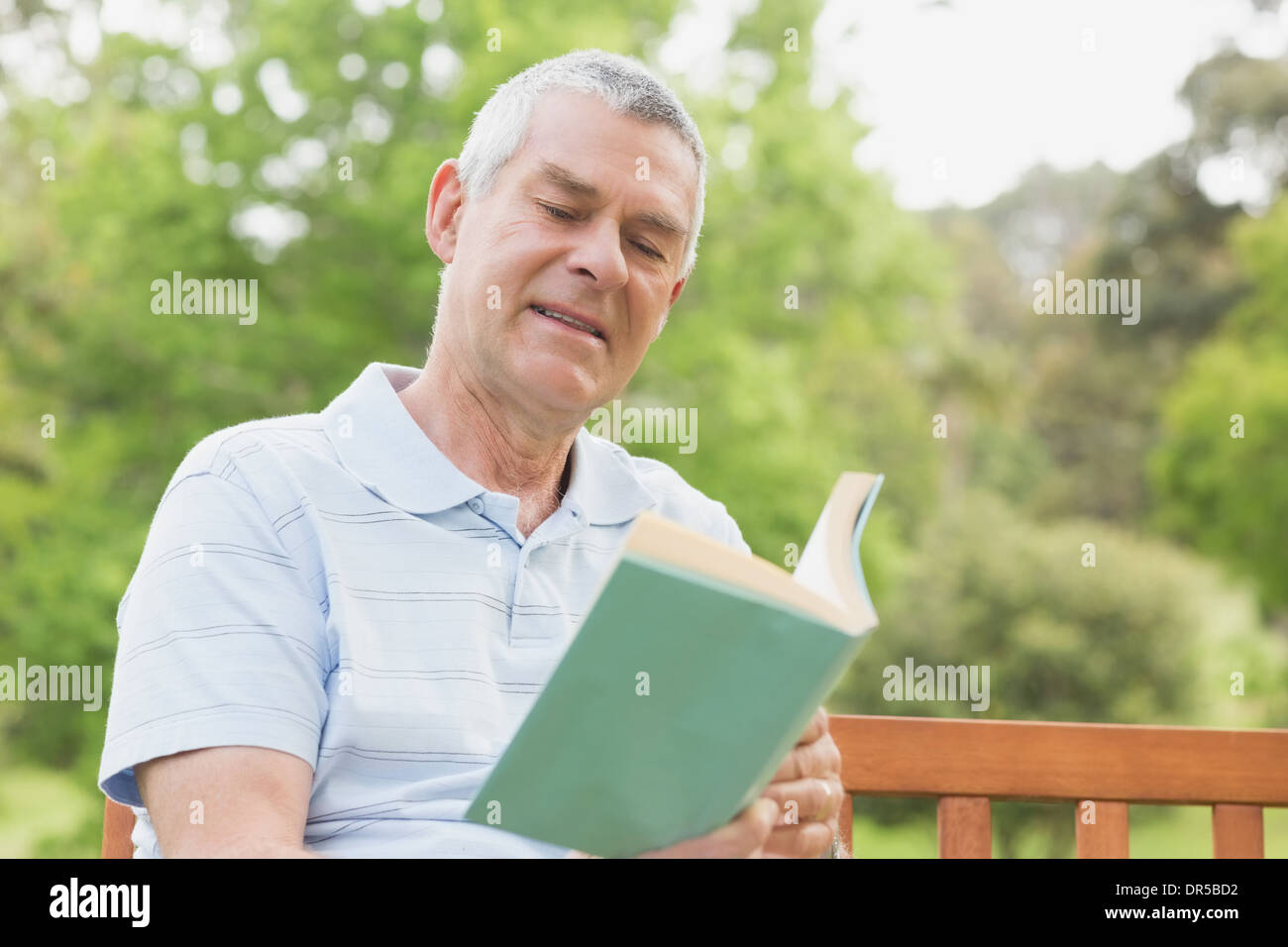 Senior man reading a book at park Stock Photo