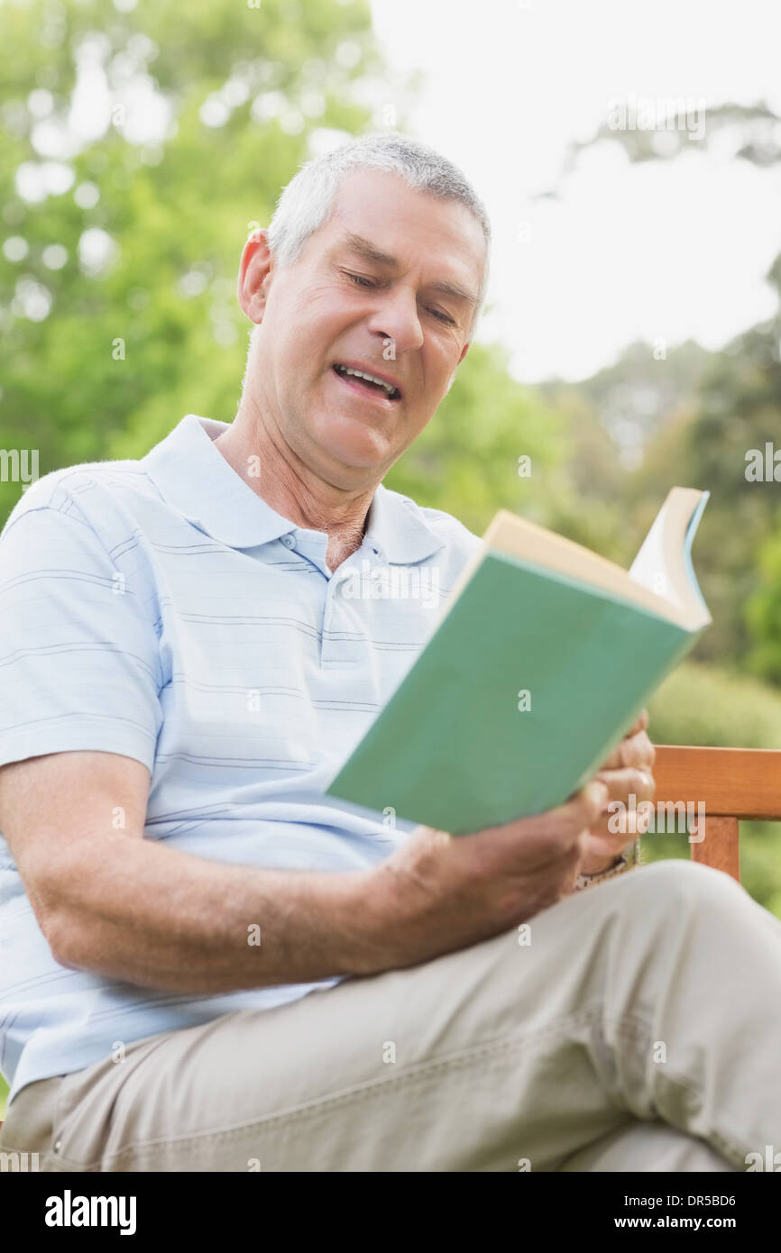 Senior man reading a book at park Stock Photo