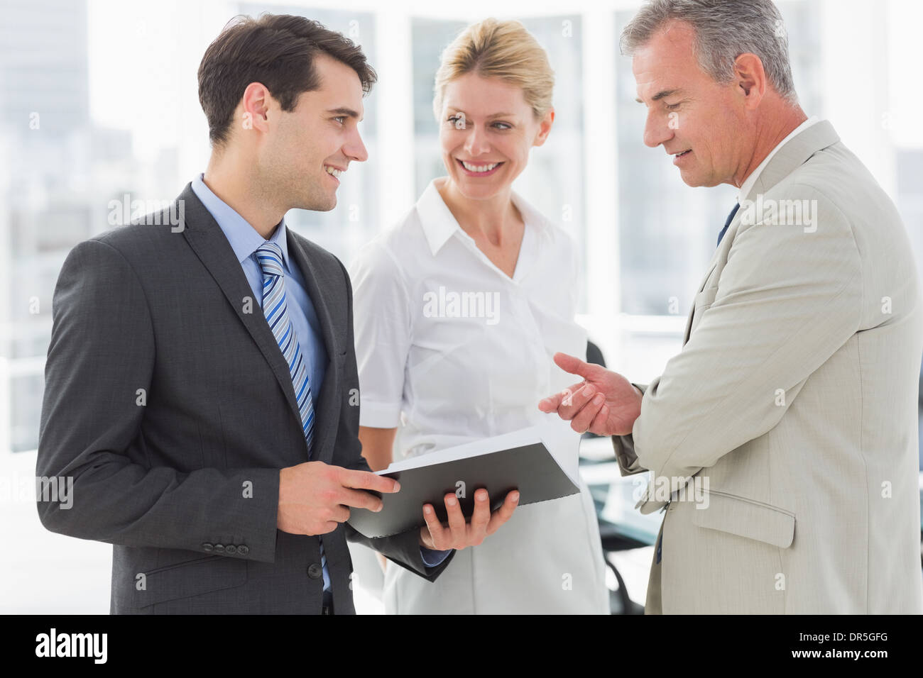 Smiling business team going over documents Stock Photo