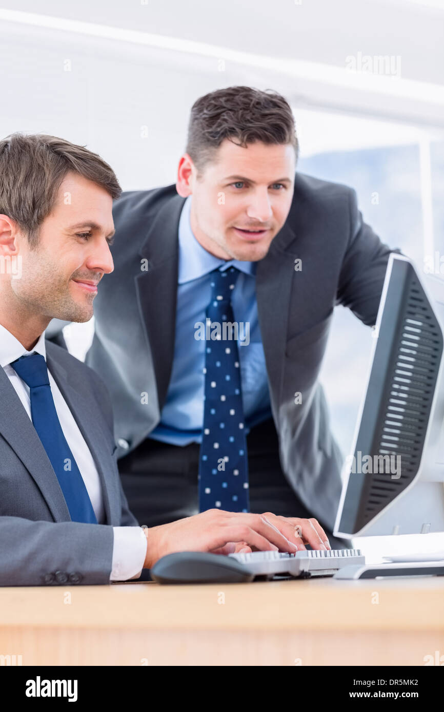 Businessmen using computer at office desk Stock Photo