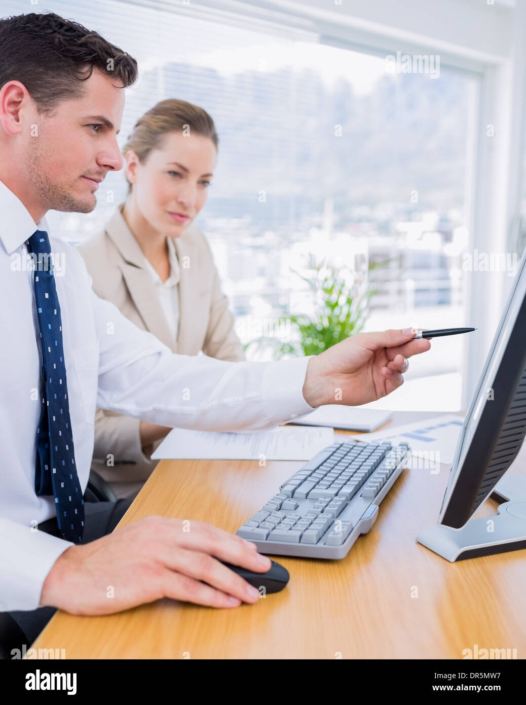 Smartly dressed colleagues using computer Stock Photo