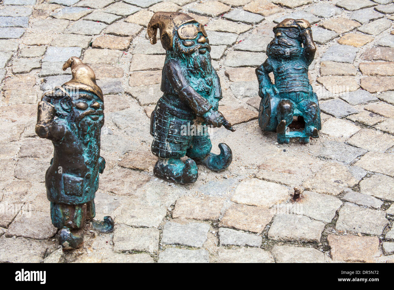 Three of Wroclaw's famous little bronze gnomes, dwarfs or krasnale statuettes. Stock Photo