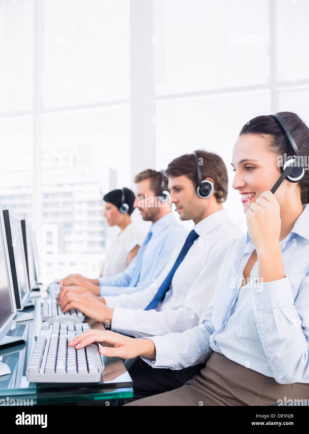 Business colleagues with headsets using computers Stock Photo