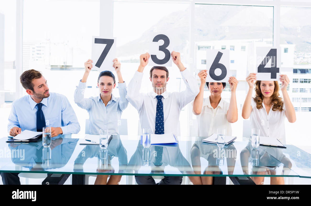 Group of panel judges holding score signs Stock Photo