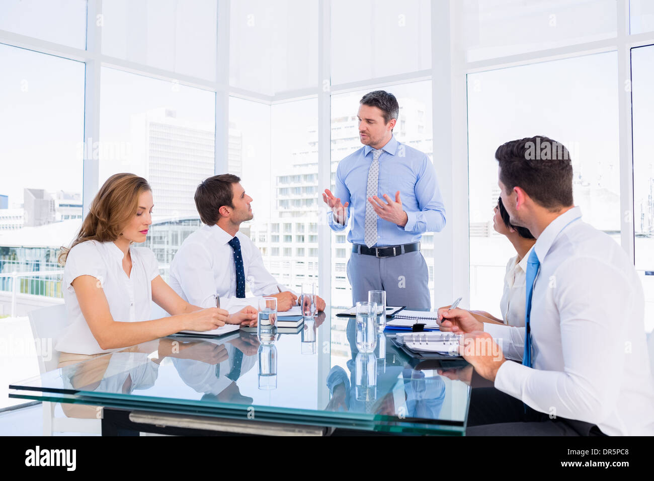Executives sitting around conference table Stock Photo Alamy