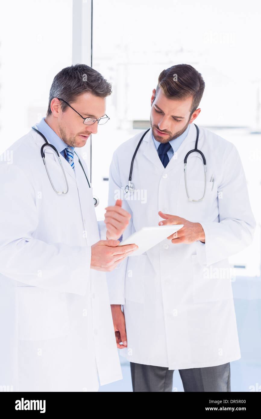Concentrated two male doctors using digital tablet Stock Photo