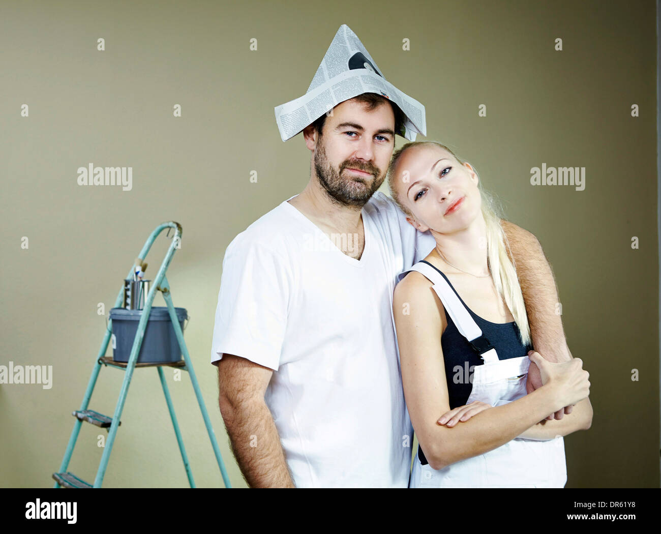Couple renovating, man wearing newspaper hat, Munich, Bavaria, Germany Stock Photo