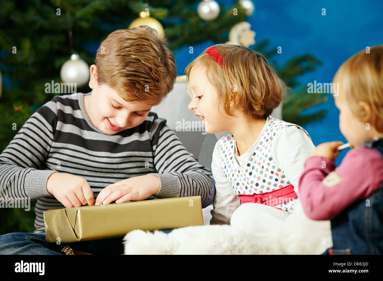 Children unwrapping Christmas presents, Munich, Bavaria, Germany Stock Photo