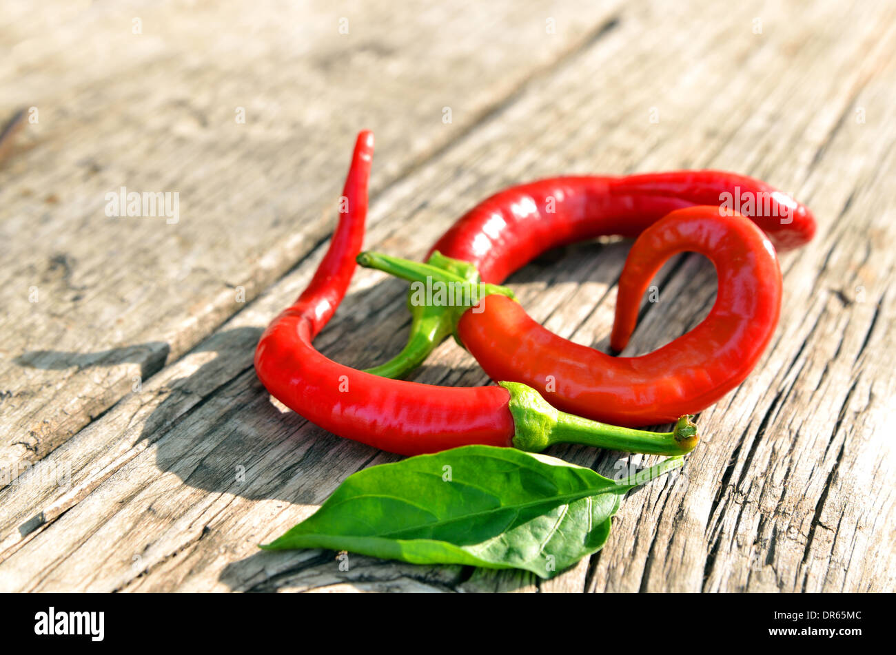 Red hot chili peppers over old wooden background Stock Photo - Alamy