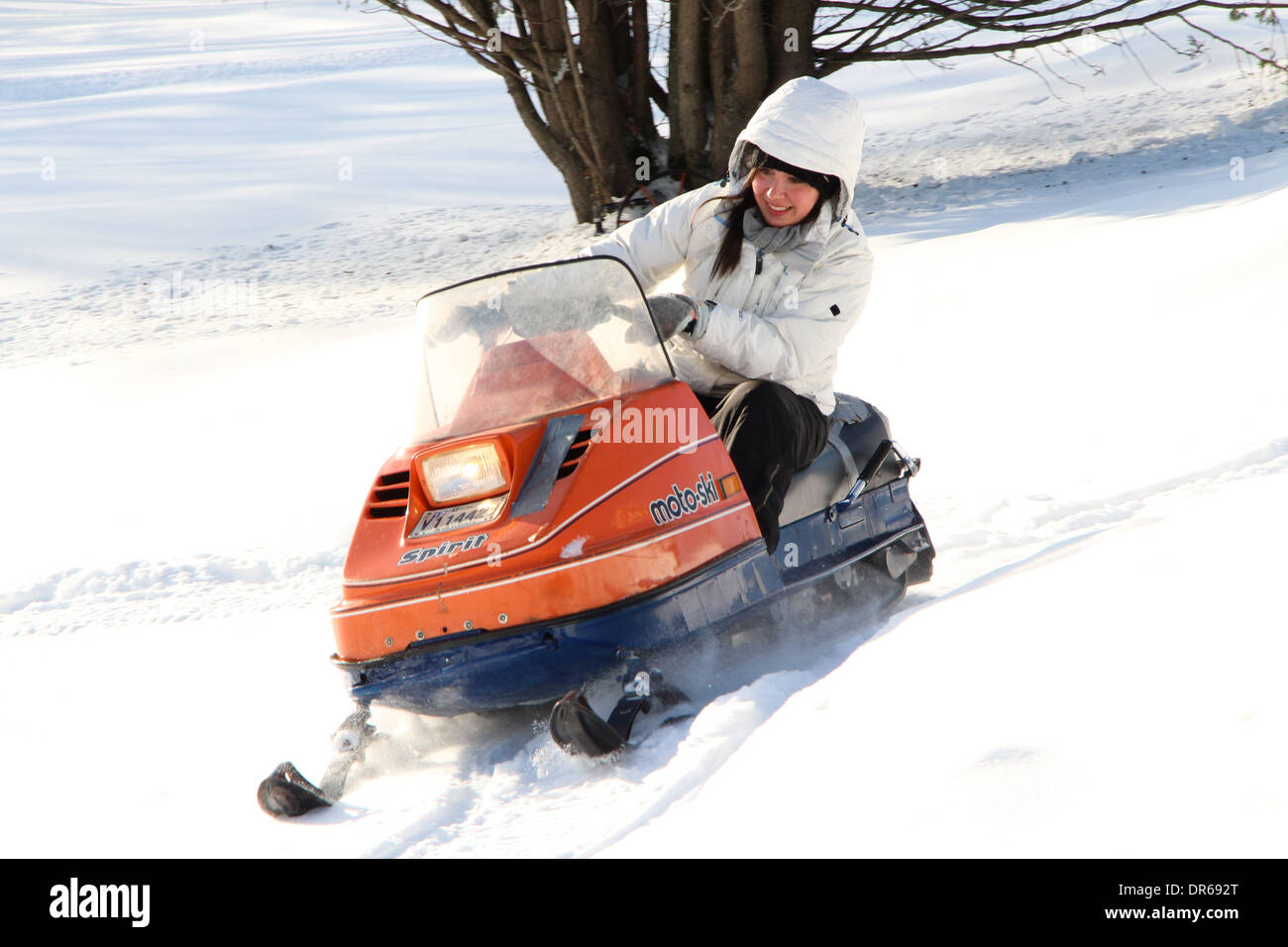 A woman in her early 30s enjoying a snowmobile ride after a fresh snowfall in Quebec, Canada. Stock Photo