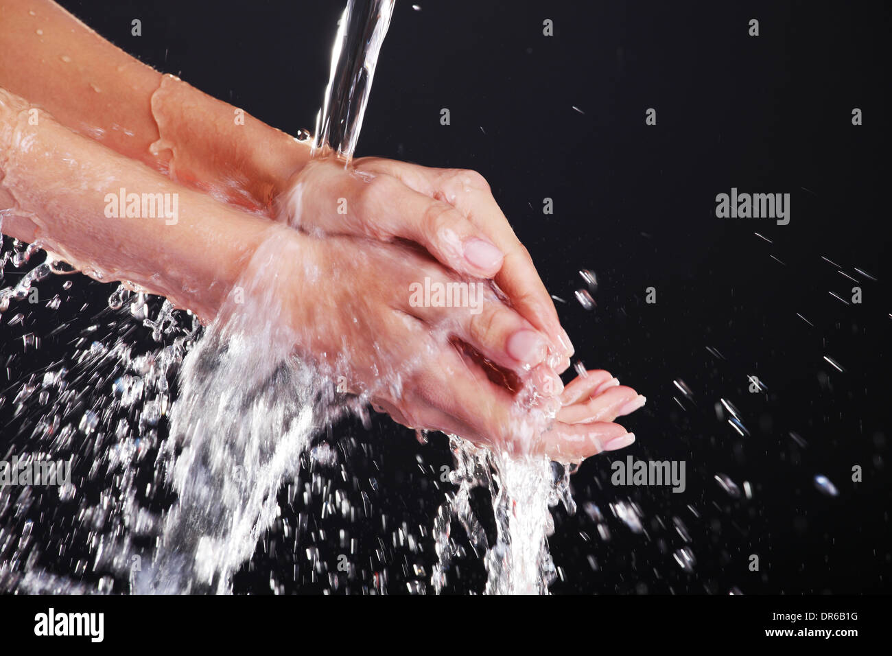 Water falling on female hands, over black background Stock Photo - Alamy