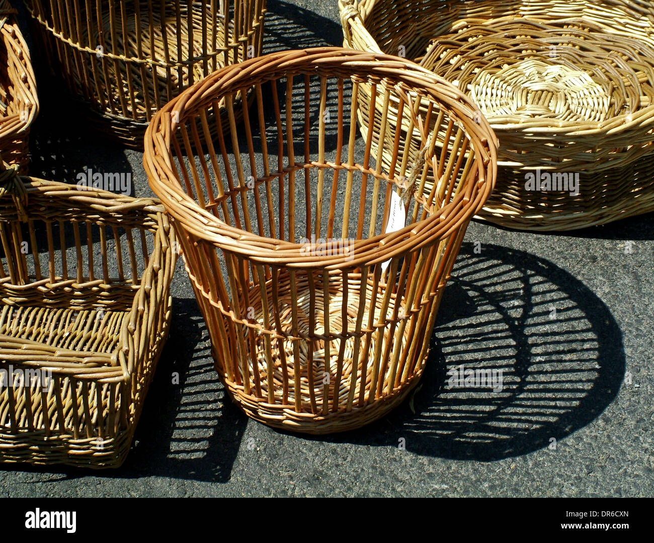 Sunshine and shadows, Wicker waste paper baskets on sale in Church Stretton in Shropshire Stock Photo