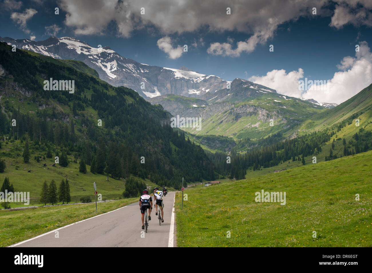 Two cyclists riding through the Unterboden valley towards the Klausenpass (1948m) in the Swiss Alps Stock Photo