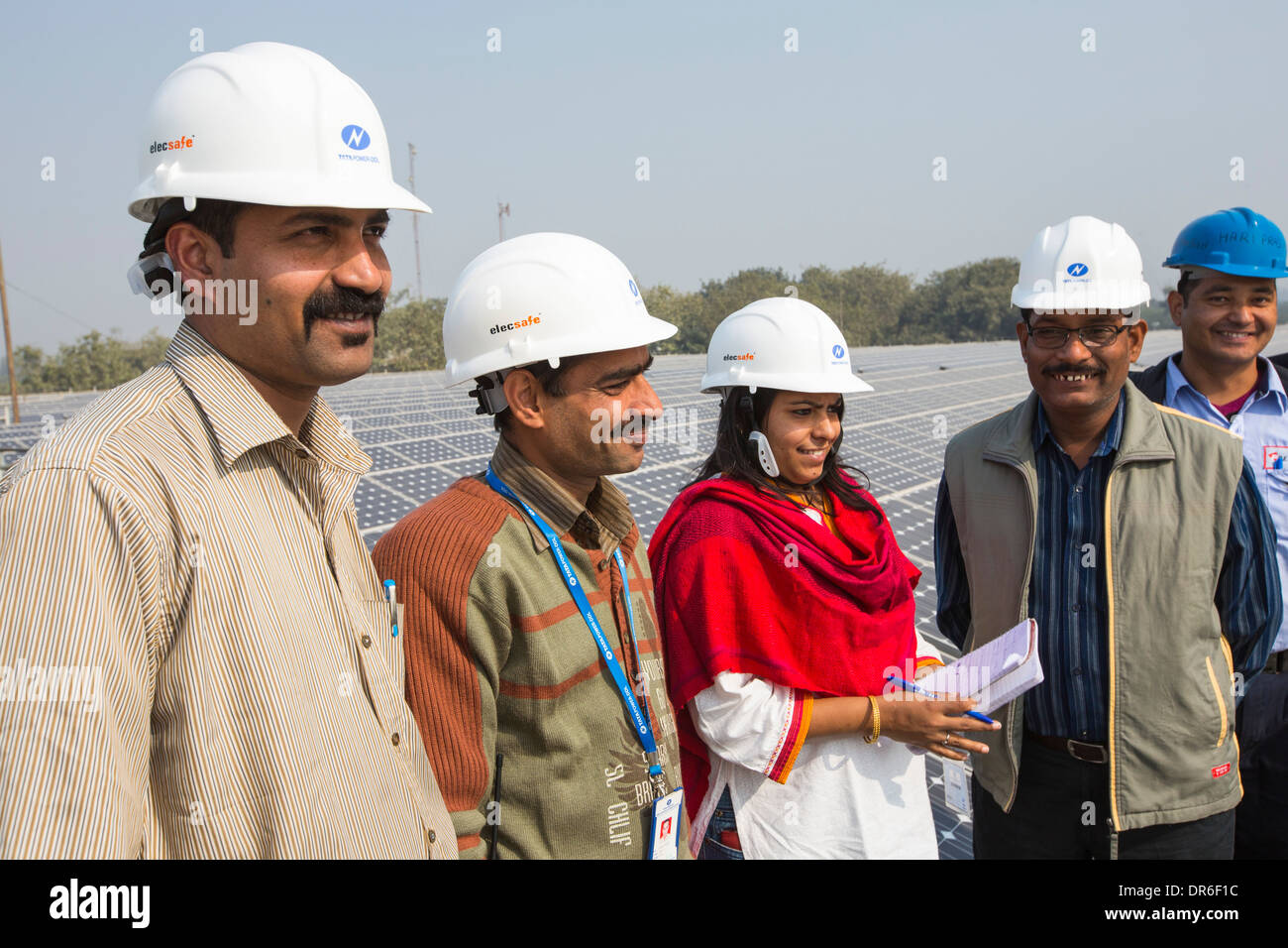 Workers at a 1 MW solar power station run by Tata power on the roof of