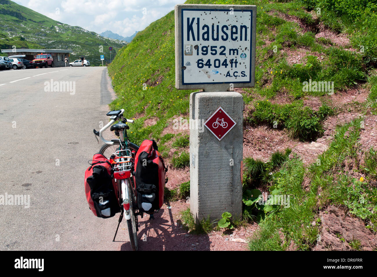 Dawes Galaxy touring bike with panniers next to the summit sign of Klausen Pass (1952m) in the Swiss Alps Stock Photo