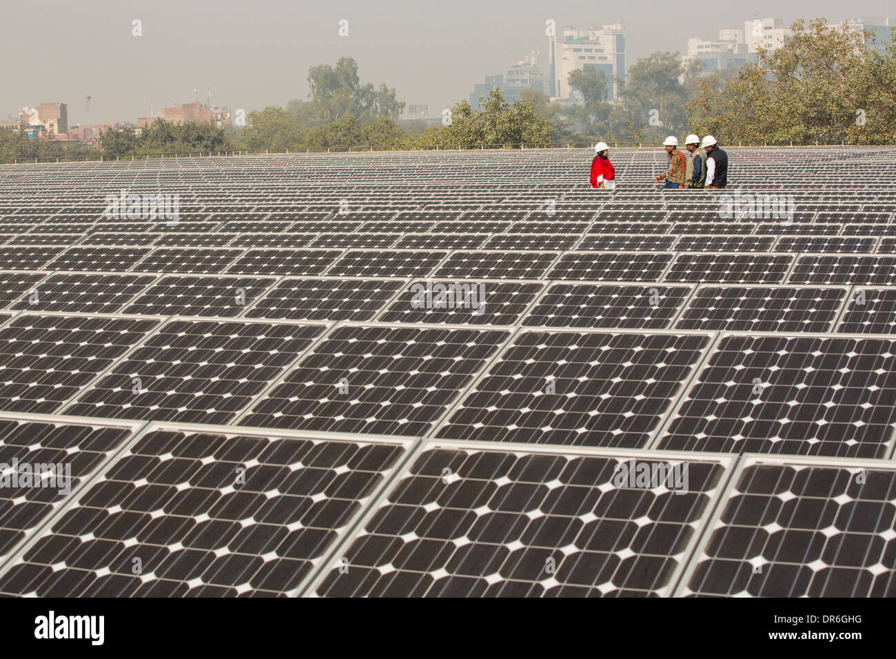 Workers at a 1 MW solar power station run by Tata power on the roof of