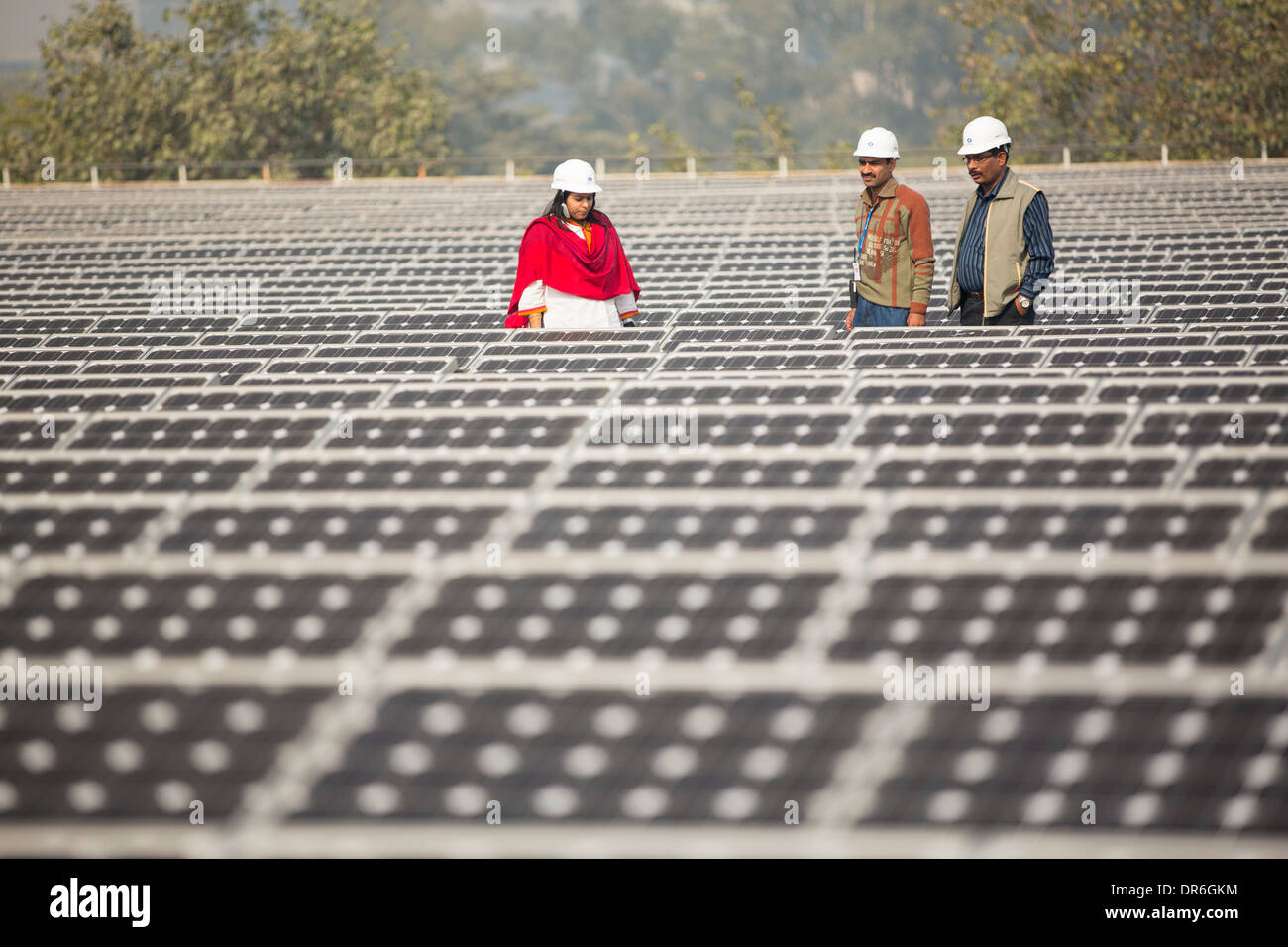 Workers at a 1 MW solar power station run by Tata power on the roof of an electricity company in Delhi, India. Stock Photo