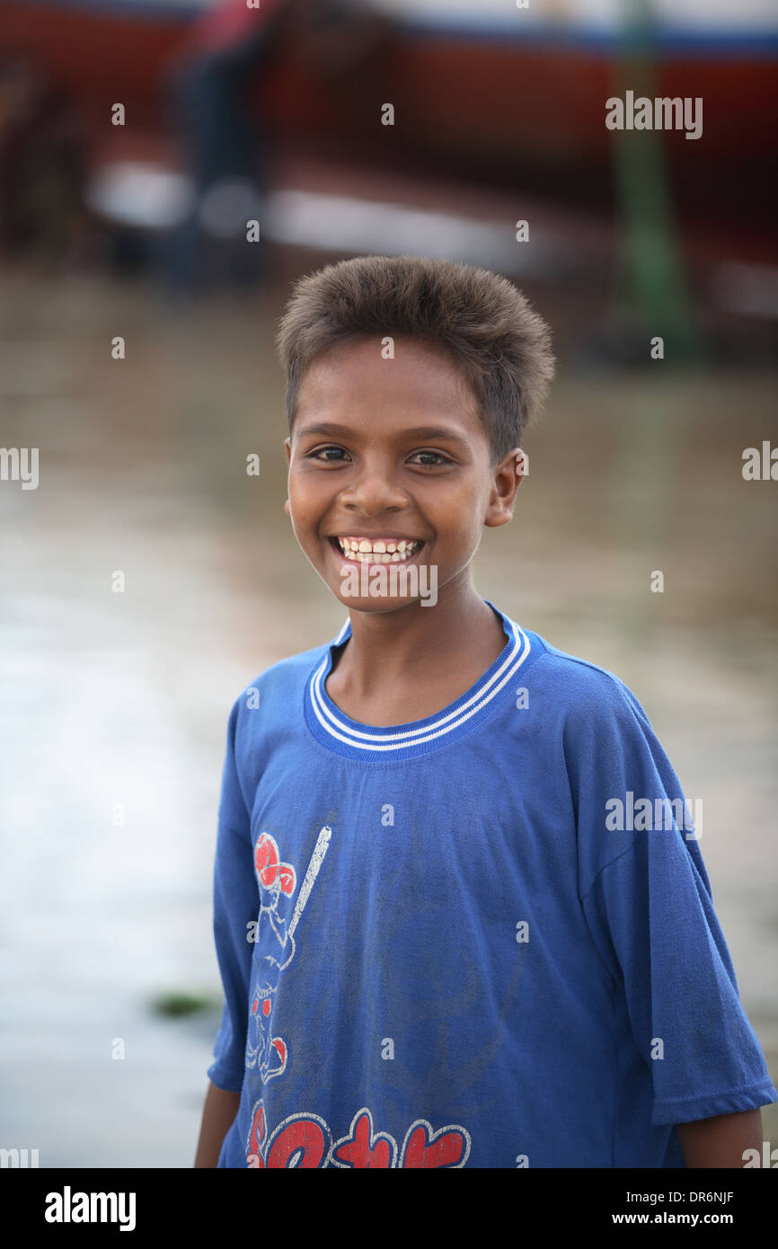Portrait of a smiling Indonesian teenage boy wearing a blue t-shirt by ocean looking at camera Kupang, West Timor, Indonesia Stock Photo
