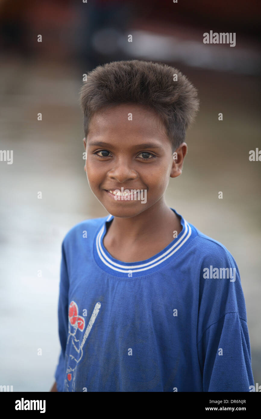 Portrait of a smiling Indonesian teenage boy wearing a blue t-shirt by ocean looking at camera Kupang, West Timor, Indonesia Stock Photo