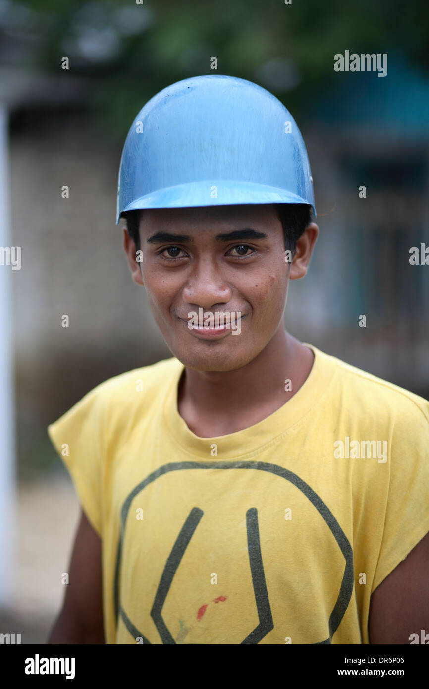 Smiling Indonesian yman wearing yellow shirt and yellowr hat.  Kupang, West Timor, Indonesia. Nov 2005 Stock Photo