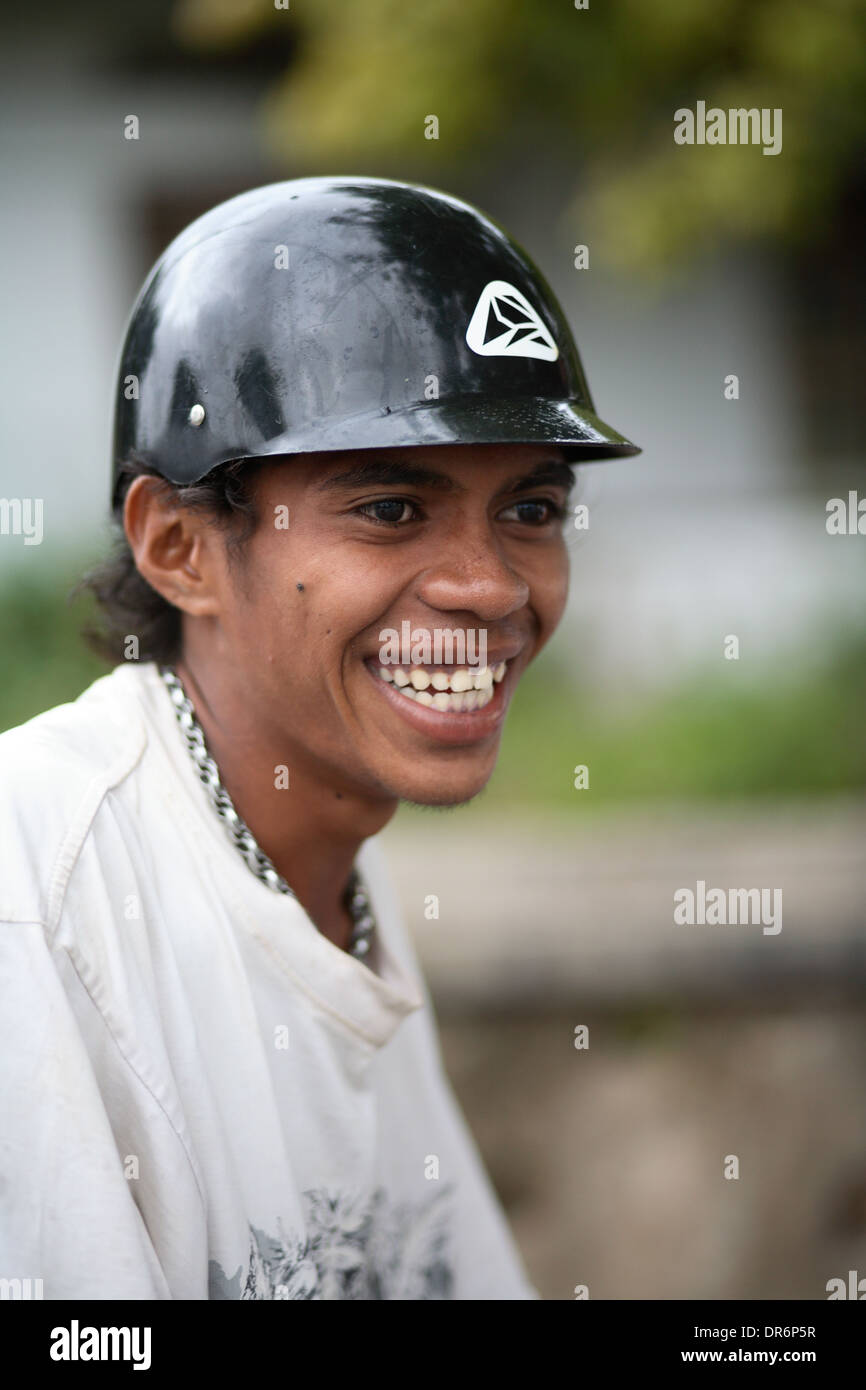 Smiling young Indonesian college student wearing motor scooter helmet.  Kupang, West Timor, Indonesia. Nov 2005 Stock Photo