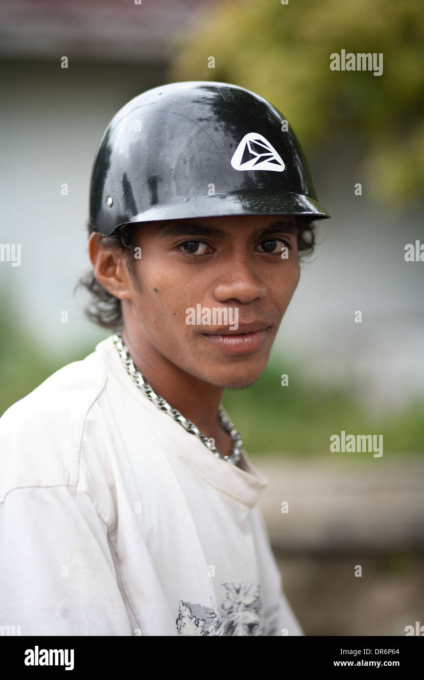 Young Indonesian college student wearing motor scooter helmet.  Kupang, West Timor, Indonesia. Nov 2005 Stock Photo