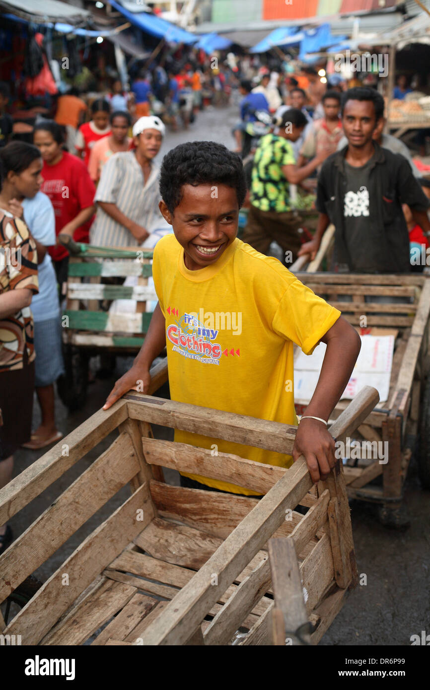 Smiling young men and teenagers pushing carts through a market in Kupang, West Timor, Indonesia. Nov 2005 Stock Photo