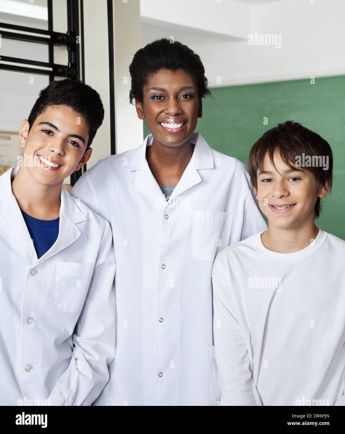 Teacher Standing With Male Schoolchildren In Classroom Stock Photo