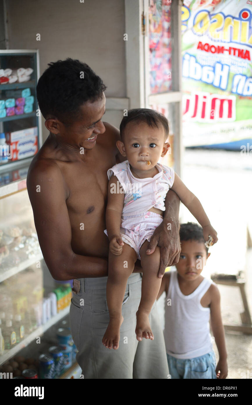 Portrait of smiling young father with child. Kupang, West Timor, Indonesia. Nov 2005 Stock Photo
