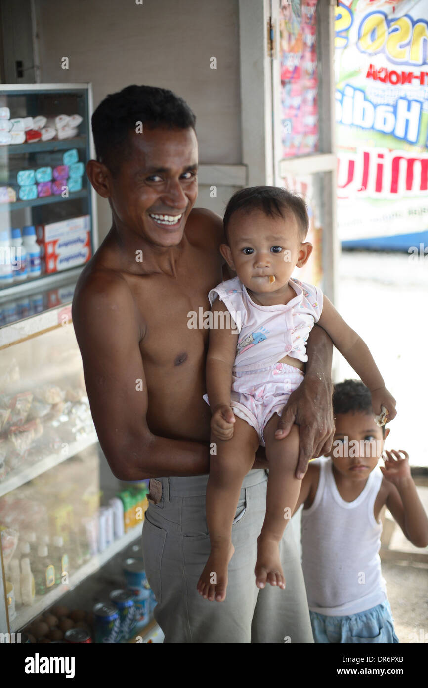 Portrait of smiling young father with child. Kupang, West Timor, Indonesia. Nov 2005 Stock Photo