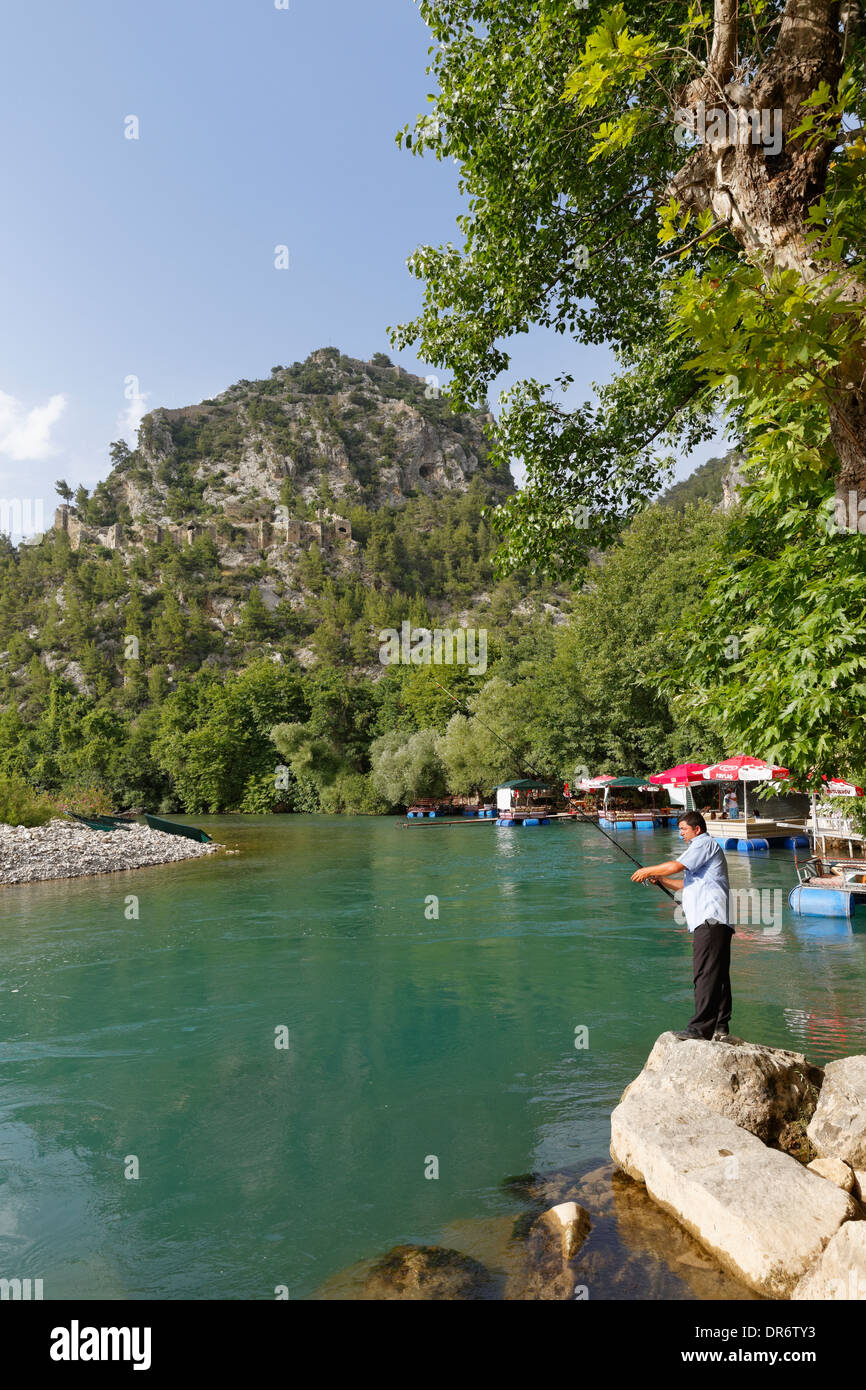 Turkey, Angler at Alara River and Alara Castle in background near Alanya Stock Photo
