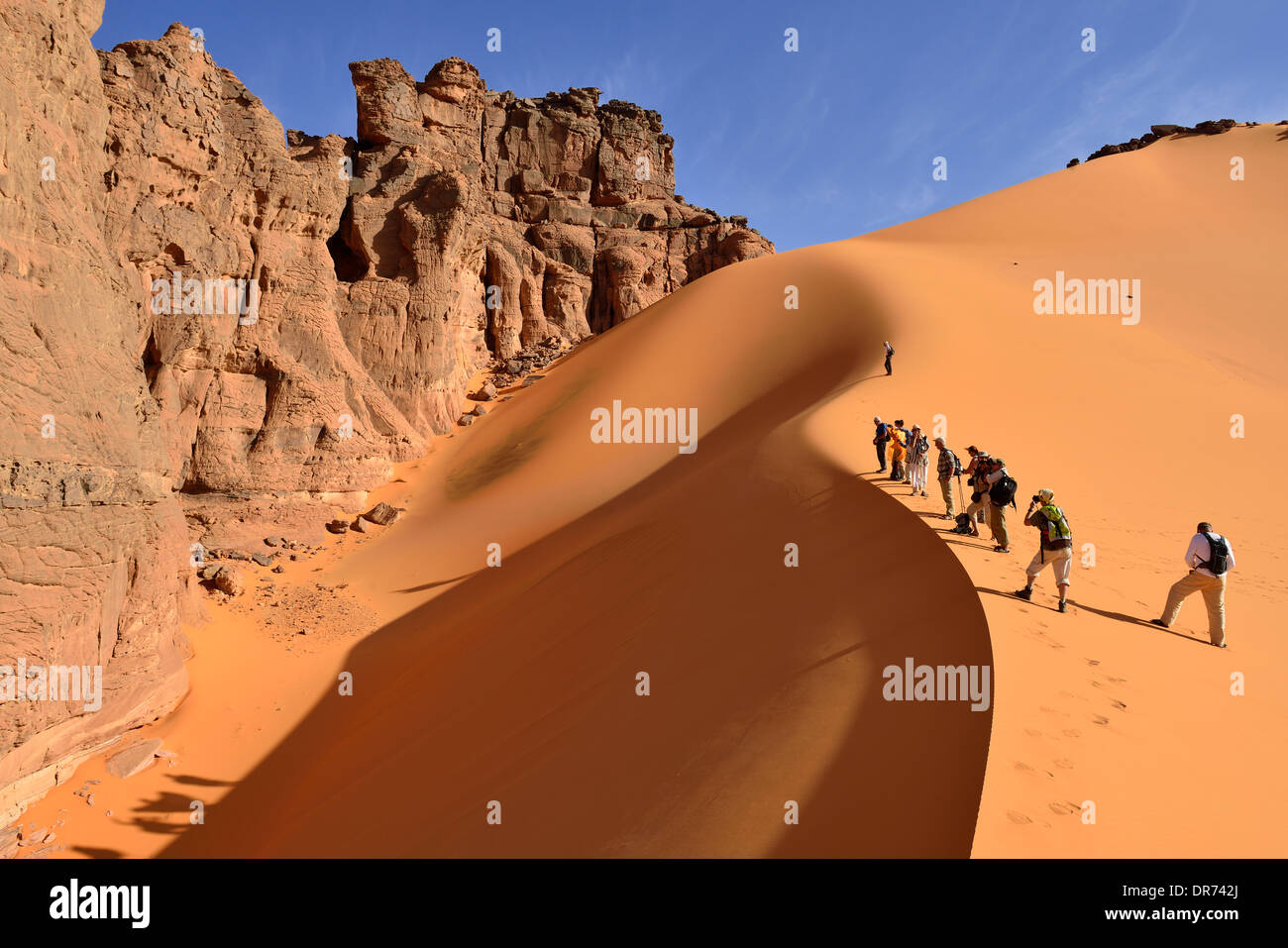 Algeria, Sahara, Tassili N'Ajjer National Park, Tadrart, group of people in the sanddunes of Moul Naga Stock Photo
