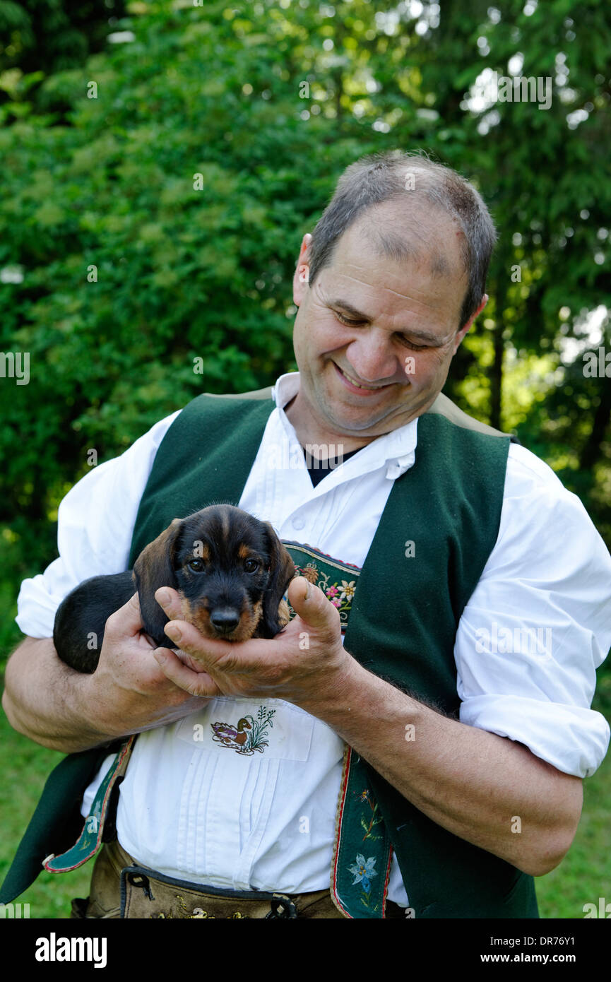 Germany, Bavaria, man in bavarian costum with young Dachshund Stock Photo