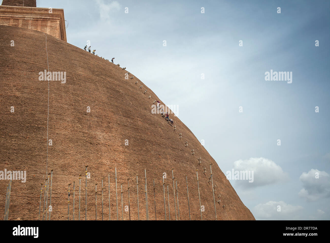 Workers descending a temple in Anuradhapura, Sri Lank during restoration work Stock Photo