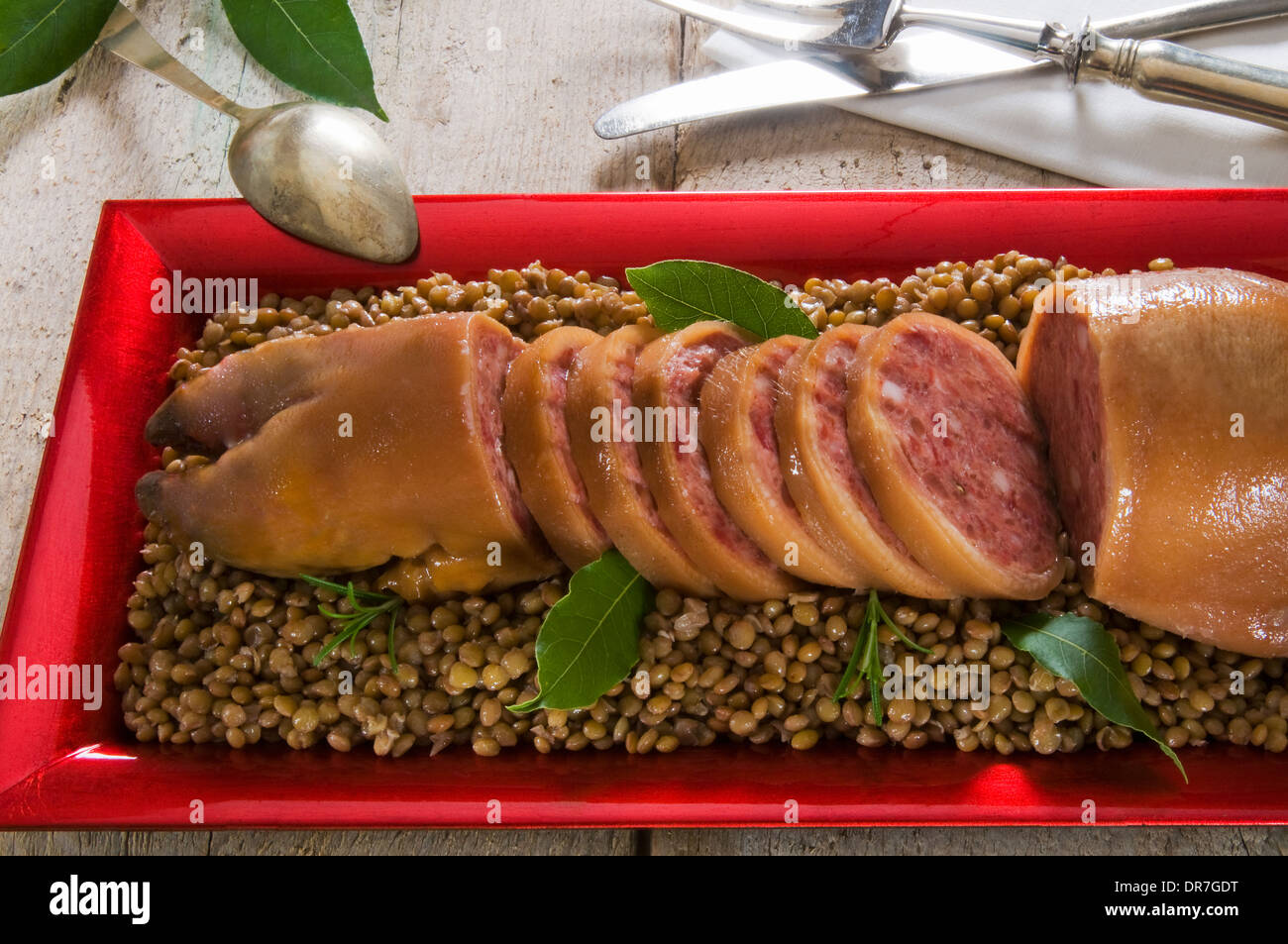 Zampone (boiled and stuffed pig's trotter) on lentils, Italian cooking, Christmas food Stock Photo