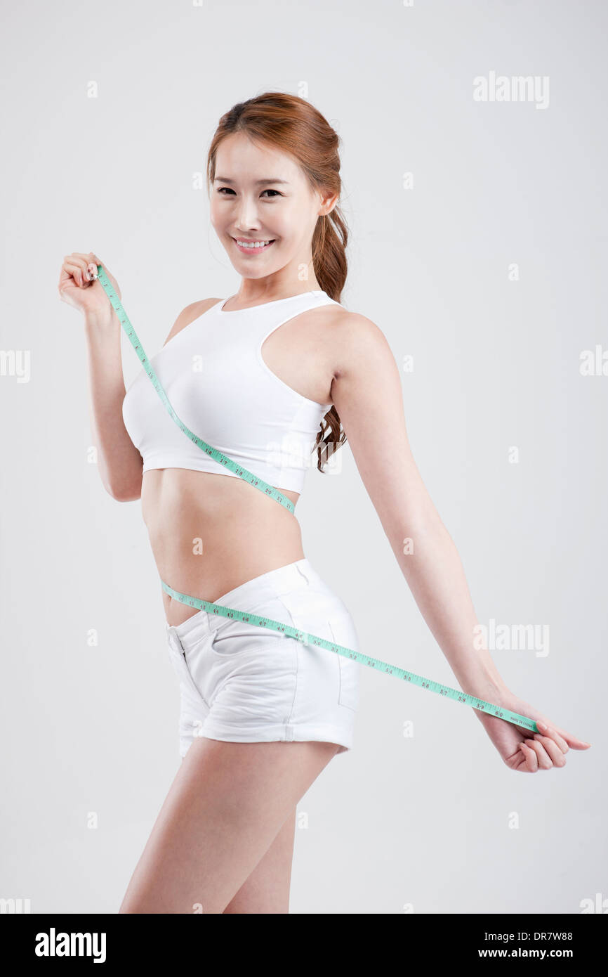 Premium Photo  Attractive female trainer holds measuring tape for body  measurement isolated on a typical background healthy lifestyle concept