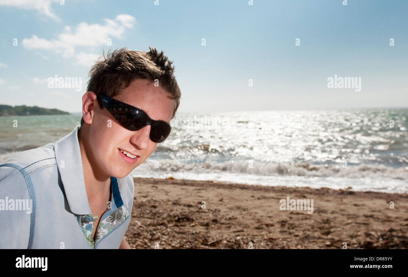 Teenage boy wearing sunglasses at the beach Stock Photo - Alamy