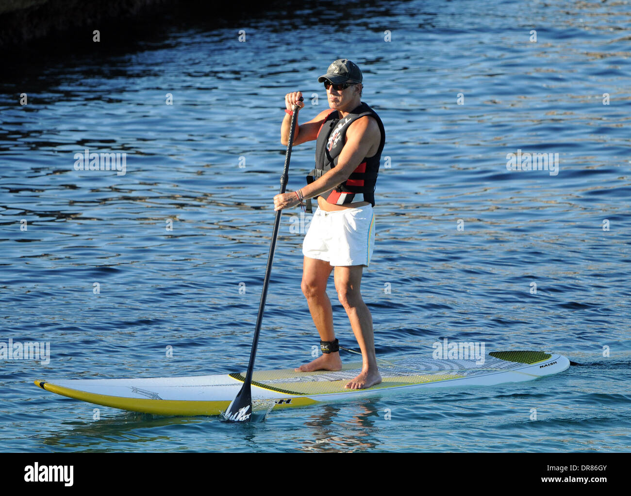 The singer Bruce Springsteen doing paddlesurf on a beach on holiday in Mallorca in 2013. Stock Photo
