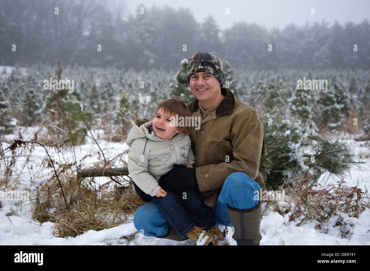 Grandfather and Grandson Posing for Photo During Outing to Cut Down a Christmas Tree in Southern Indiana Stock Photo