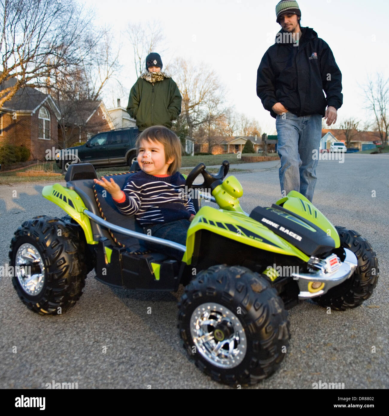 Toddler Driving Toy Dune Buggy While Parents Supervise Stock Photo