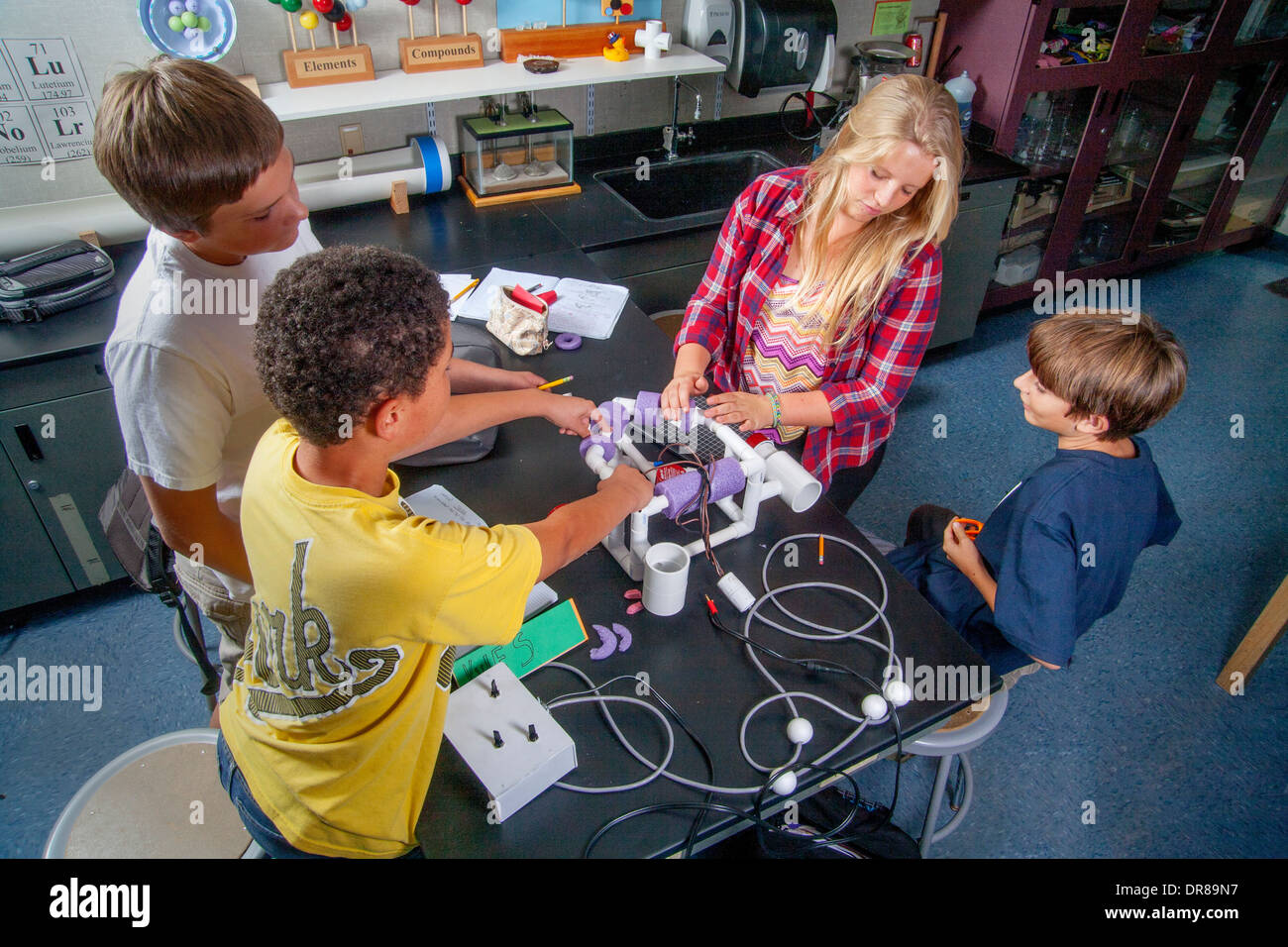 Multiracial middle school students in Mission Viejo, CA, test the remote operated vehicle (ROV) they built in their robotics classroom. Stock Photo